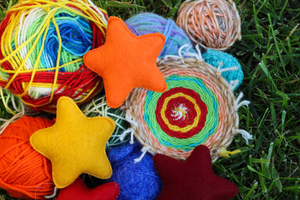 istock Colorful knitting balls from wool and fabric textile stars on green grass 658480938