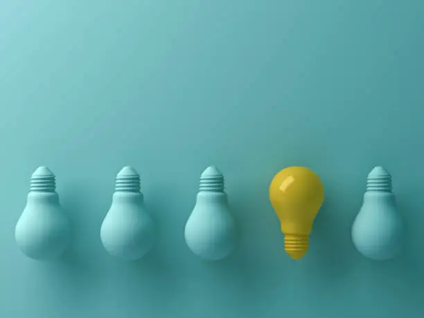 Photo of Think different concept , One yellow light bulb standing out from the unlit green incandescent lightbulbs with reflection and shadow , leadership and different creative idea concept. 3D render