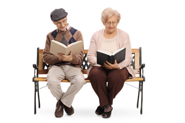 istock Seniors sitting on a bench and reading books 658486868