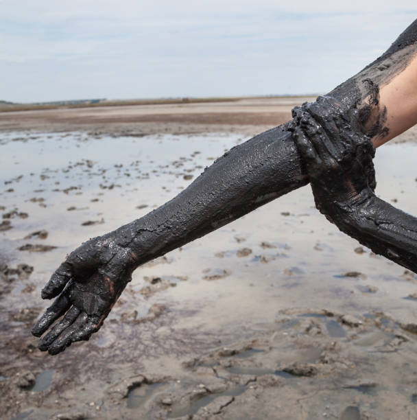istock Smearing black healing mud on the arm. 658487336