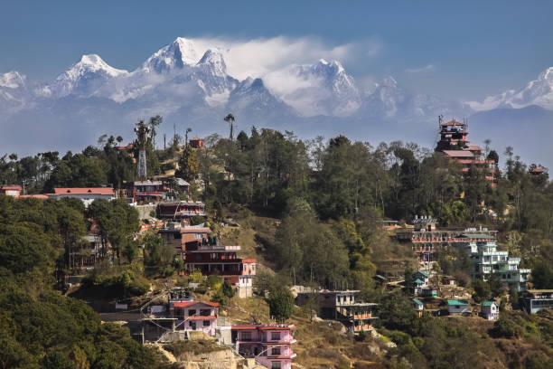 View to majestic Himalayan mountains of Langtan range with buildings on smaller hills in foreground, Nagarkot Nepal nagarkot photos stock pictures, royalty-free photos & images