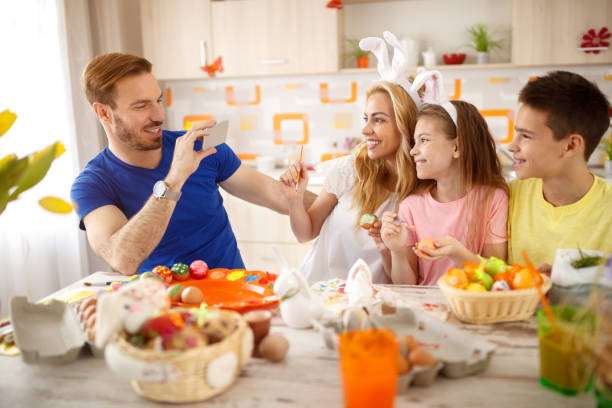 istock Father take photo to his family while coloring eggs 658494270