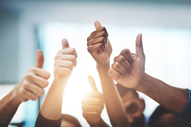 Keep up the amazing work! Cropped shot of a team of colleagues showing thumbs up at work congratulating stock pictures, royalty-free photos & images