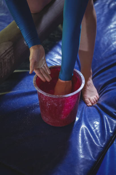istock Female gymnast applying chalk powder on her hands before practicing 658495726