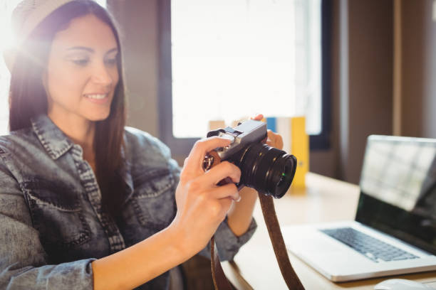 istock Graphic designer looking at pictures in digital camera 658502010