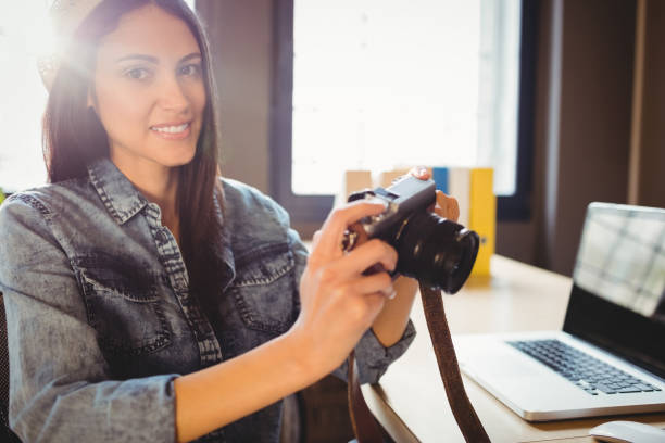 istock Graphic designer looking at pictures in digital camera 658502046