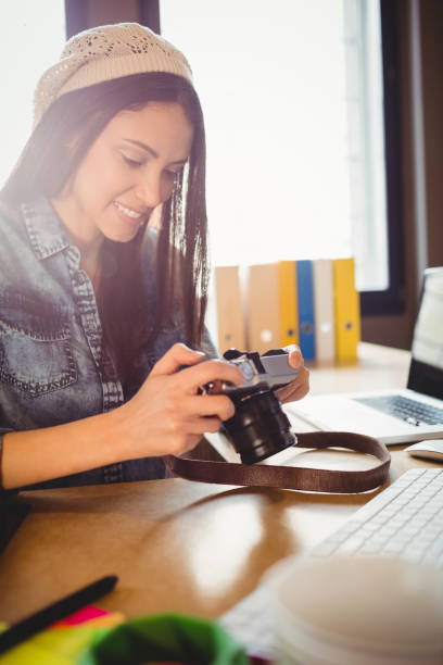 istock Graphic designer looking at pictures in digital camera 658502148