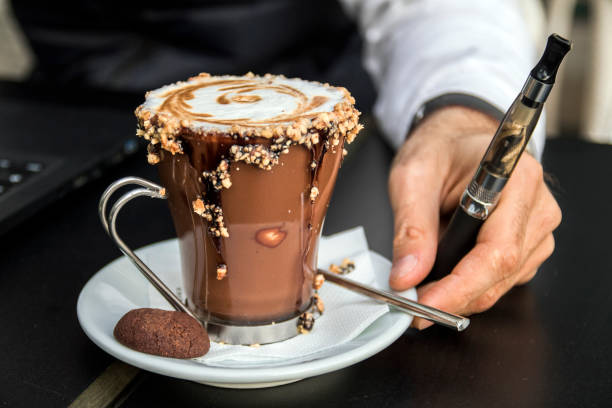 istock Stylish man with laptop, coffee and e-cigarette. 658502380