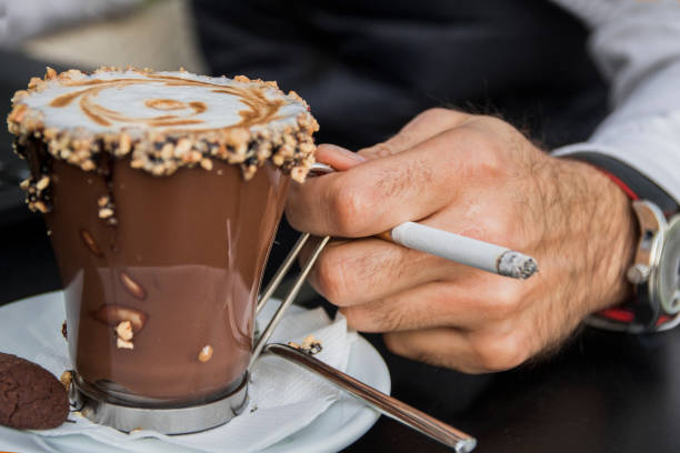 istock Man's hand with a cigarette and a cup of coffee 658502510