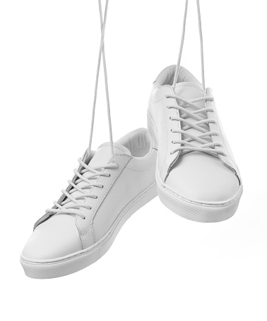 White sneakers hanging isolated on white