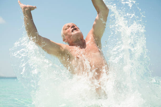 istock Senior man jumping out of sea 658506018
