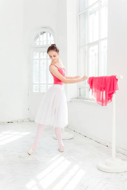 ballerine posant dans des chaussons de pointe au pavillon en bois blanc - women dancing contemporary red photos et images de collection