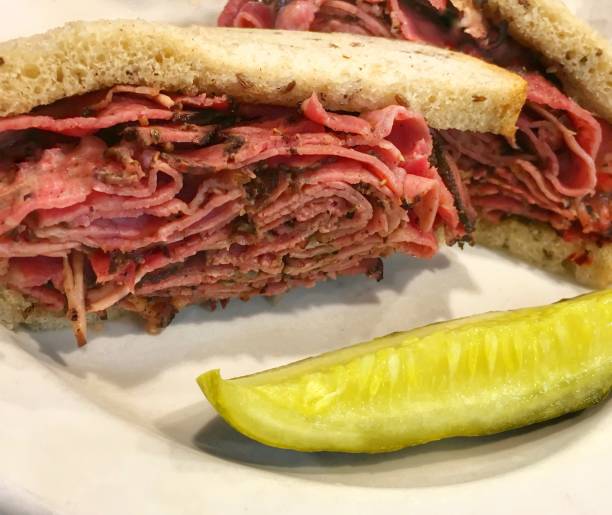 Hot Pastrami Sandwich Hot pastrami sandwich on a plate with a slice of dill pickle pastrami stock pictures, royalty-free photos & images