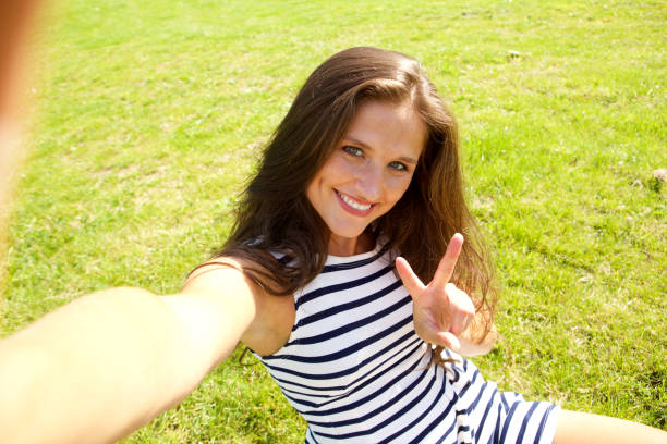 istock young happy woman on grass taking selfie 658520798