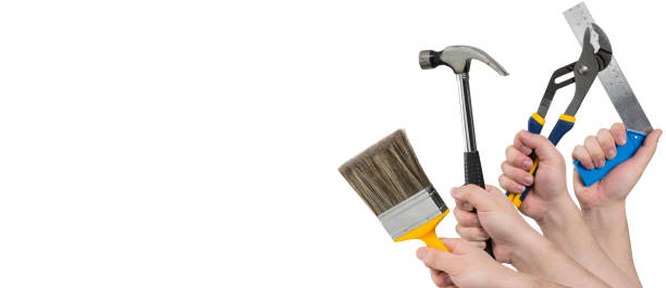 istock Hands Holding Paintbrush, Hammer, Pliers, and Square Ruler 658531326