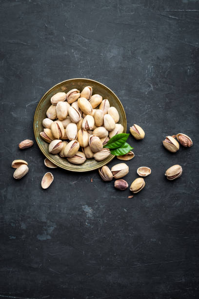 istock Pistachio nuts on dark background, top view, healthy snack 658535694