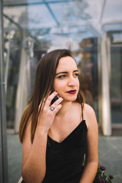 Young woman speaking on the phone A young woman sitting and speaking on the phone tecnología inalámbrica stock pictures, royalty-free photos & images