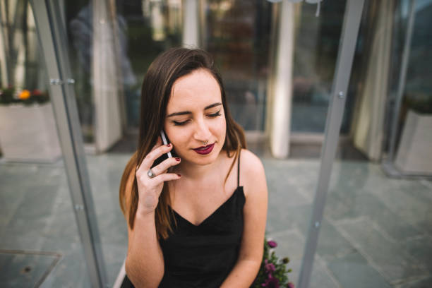 Young woman speaking on the phone A young woman sitting and speaking on the phone escapada urbana stock pictures, royalty-free photos & images