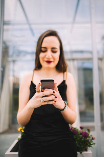 Young woman using smartphone A young woman holding an smartphone tecnología inalámbrica stock pictures, royalty-free photos & images