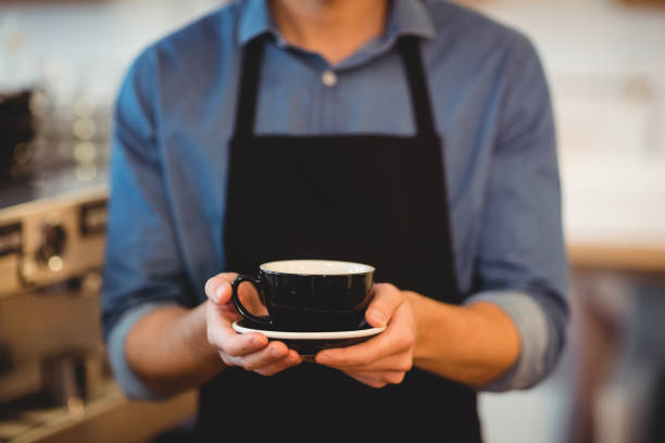 Mid section of man holding cup of coffee
