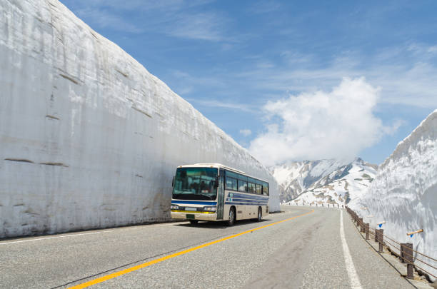 blur windshield bus move along snow wall at japan alps tateyama kurobe alpine route - hida bergketen stockfoto's en -beelden