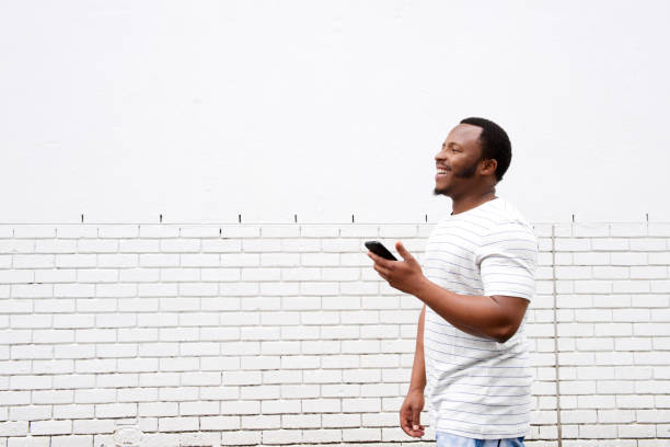 istock cool african american guy walking with mobile phone 658550844