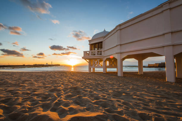 романтический закат на пляже кадис со знаменитым пирсом - andalusia beach cadiz spain стоковые фото и изображения