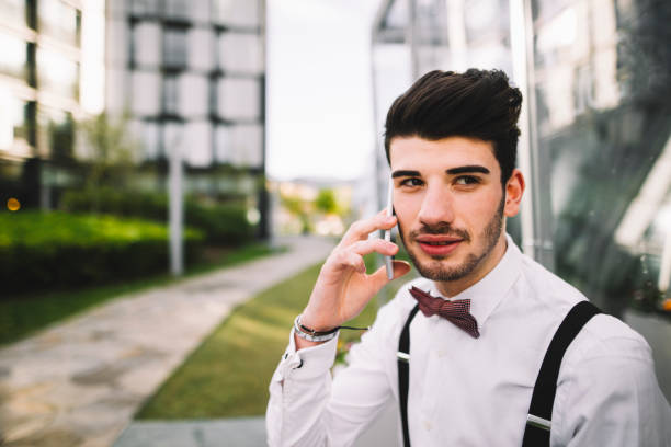 Young man speaking on the phone A young man wearing a suit and speaking on the phone tecnología inalámbrica stock pictures, royalty-free photos & images