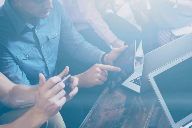 istock Young team of coworkers making great work discussion in modern office.Man showing presentation on digital tablet.Business people meeting concept.Horizontal, blurred background. 658555532