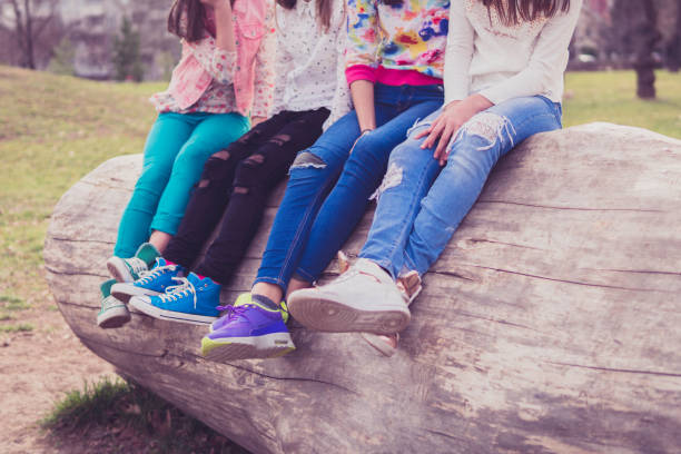 istock Four kids resting on tree log in park 658557358