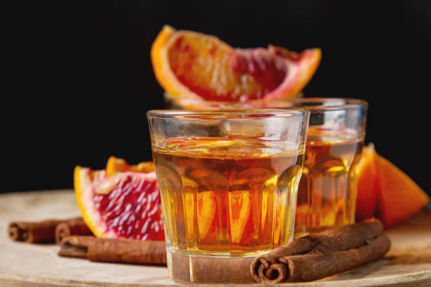 istock Golden tequila with red orange and cinnamon. Dark background. Se 658561648