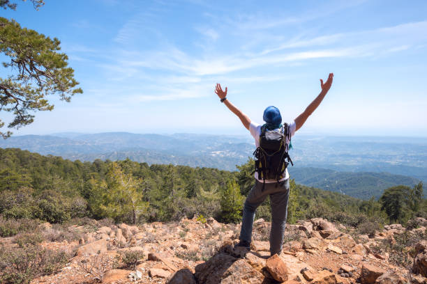 homem feliz com a mochila fica em uma encosta rochosa - montanhas de troodos - fotografias e filmes do acervo