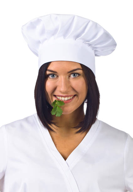 istock young woman in chef uniform with parsley isolated on white 658565032