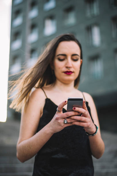 Young woman using smartphone A young woman holding an smartphone tecnología inalámbrica stock pictures, royalty-free photos & images