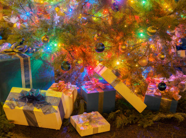 Christmas gift boxes stacked under the decorated tree