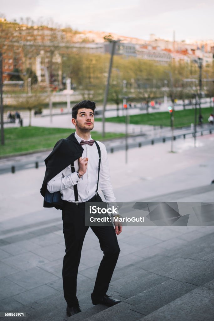 Young man wearing a suit going up A young man moving forward in a staircase wearing a suit 20-29 Years Stock Photo