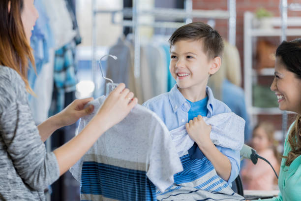 adorable little boy shops with his mother - boutique shopping retail mother imagens e fotografias de stock