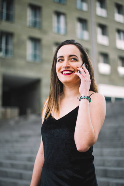 Young woman speaking on the phone A young woman sitting and speaking on the phone escapada urbana stock pictures, royalty-free photos & images