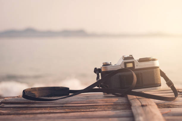istock Retro camera with beautiful landscape at the sea 658572232