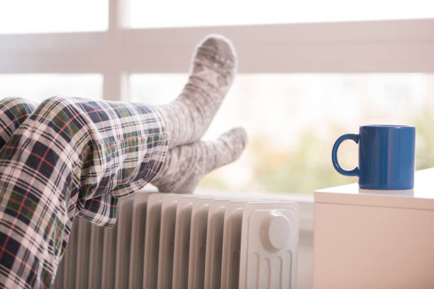 istock Unrecognized woman warming up her feet in winter. 658574590