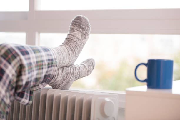 istock Unrecognized woman warming up her feet. 658574702