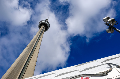 Vertical view of a famous Canadian concrete tower seen at the heart of Toronto. The tower is very tall, a famous landmark and tourist destination and the observation tower can be seen at the top.
