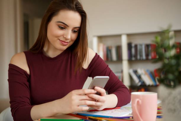 istock Young happy woman using mobile phone at home 658577802