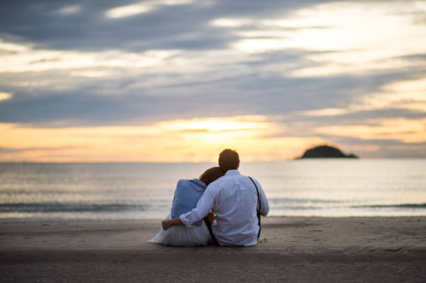 istock Couple watching sunset in the beach romantic scene 658580930