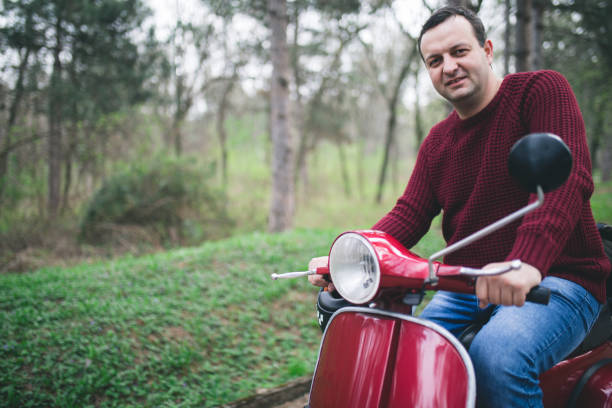 istock Young hipster man in helmet sitting on a vintage scooter . 658584316