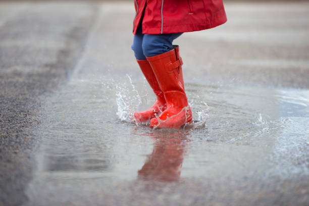 istock Kid jumping on puddles in rainy day. 658584542