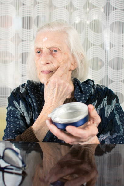 istock Senior woman applying face cream 658595384