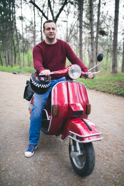 istock Young hipster man in helmet sitting on a vintage scooter . 658596504