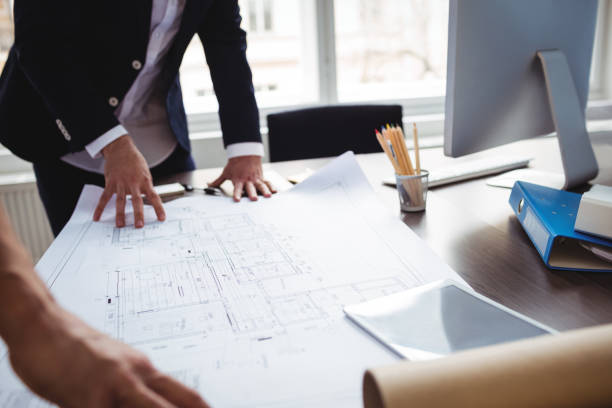 istock Interior designer discussing blueprint with coworker 658596796