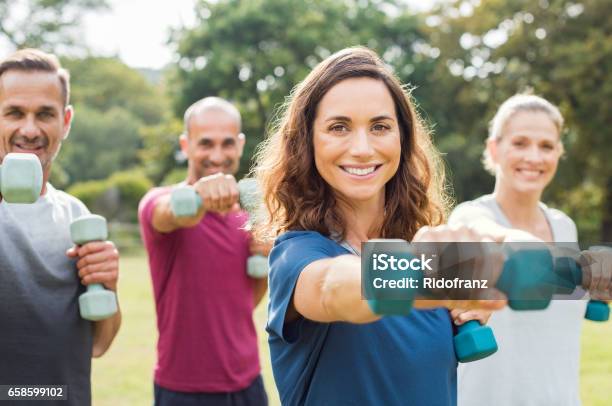 People Using Dumbbells Stock Photo - Download Image Now - Exercising, Group Of People, Outdoors